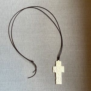 Ivory cross necklace on a brown leather cord